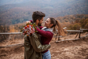 couple amoureux qui se regarde dans les yeux avec bouquet de fleur