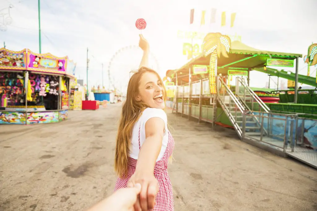 fille qui donne la main à son amour à la fête foraine 