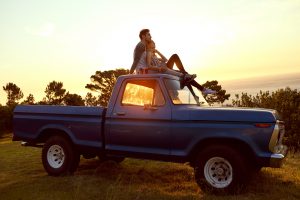 vcouple sur le toit d'une voiture pendant un coucher de soleil