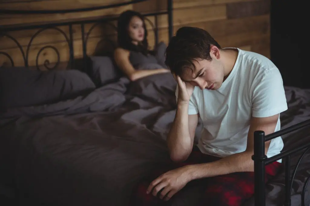 Couple mécontent s'ignorant après s'être disputé sur le lit dans une chambre à coucher