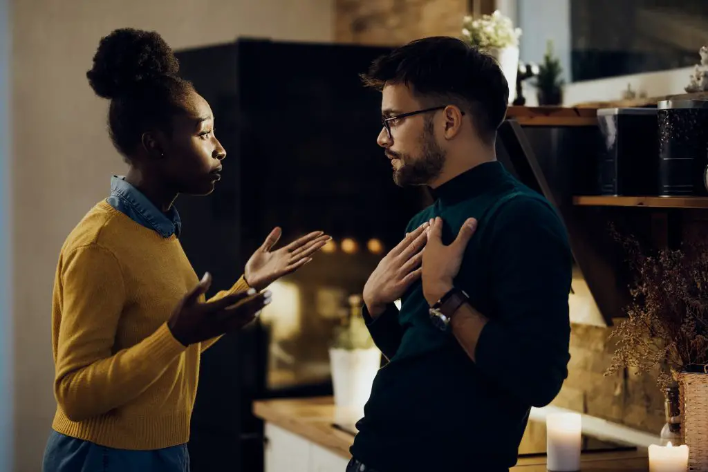 Jeune femme afro-américaine discutant avec son petit ami des problèmes de leur relation à la maison.