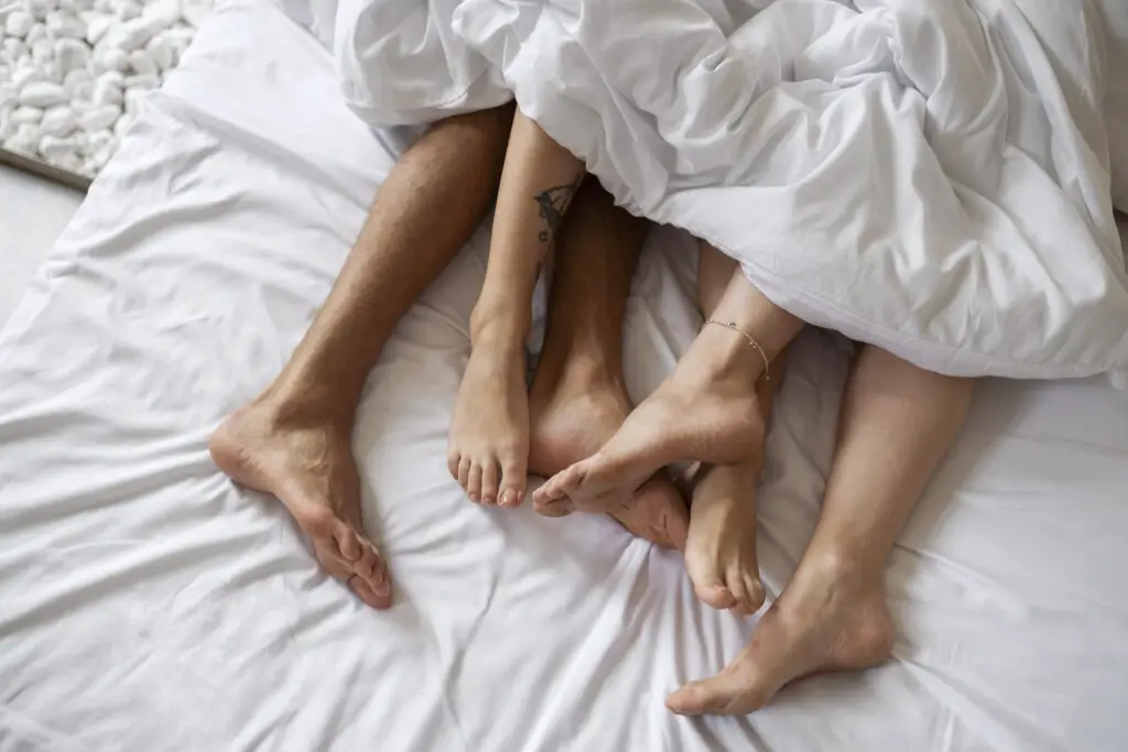 Couple en relation libre dans un lit 