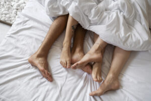 Couple en relation libre dans un lit