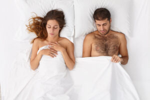 homme et femme dans un lit qui ne se touchent pas